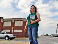 Anne Dinshah stands holding her new book "Powerful Vegan Messages" in front of the now closed Cross Bros. Meat Packing Co. on Monday, June 30, 2014.  (C.F. Sanchez / Staff Photographer)
