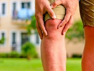 Man holding a painful knee.